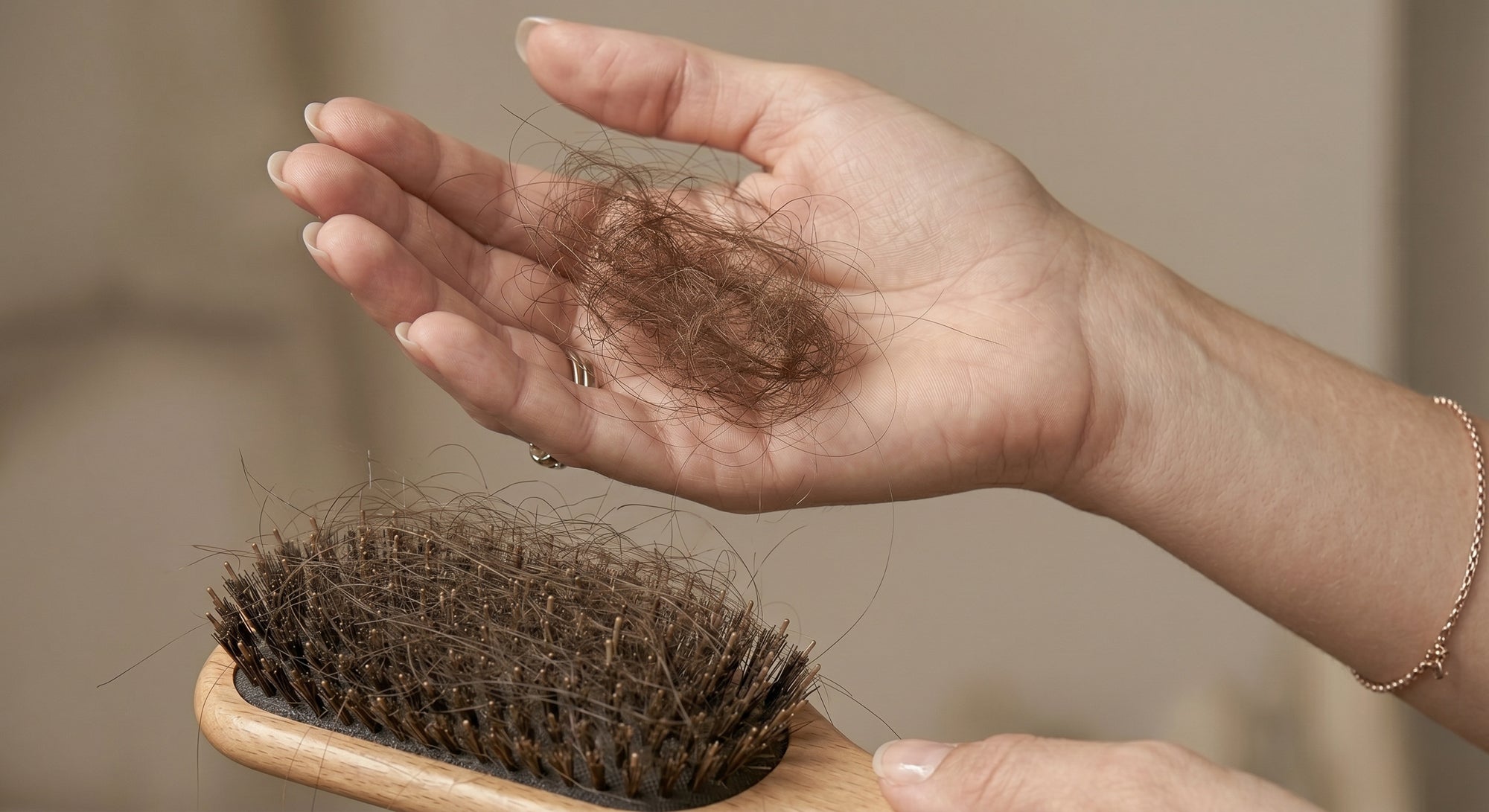 close-up of hand holding hair strands fallen from brush showing excessive hair shedding and hair loss concern
